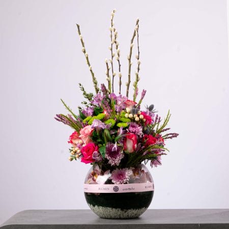 Elegant purple and pink flower arrangement with roses and alstroemeria in a round BLUMEN vase.