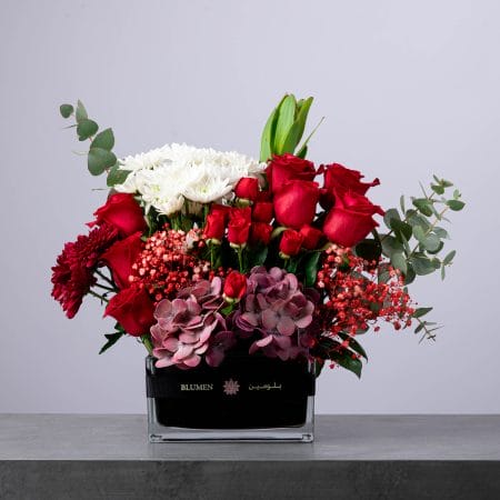 تنسيق زهور حمراء وبيضاء فاخرة في مزهرية مستطيلة من بلومن