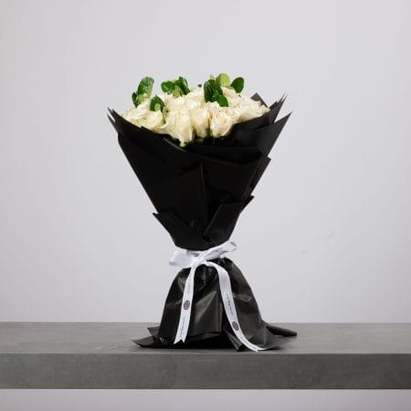 White rose bouquet wrapped in black paper with white ribbon