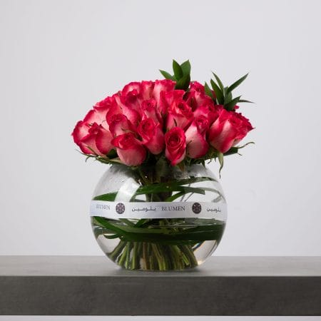 Pink rose bouquet arranged in a clear round glass vase