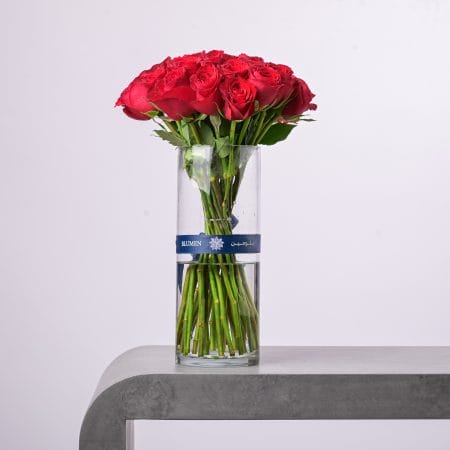 Contemporary floral arrangement with orange roses and white blooms in a glass vase.