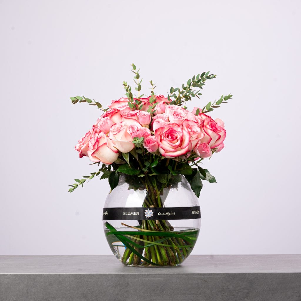 Elegant bouquet of red roses wrapped in deep red mesh with a blue BLUMEIN ribbon.