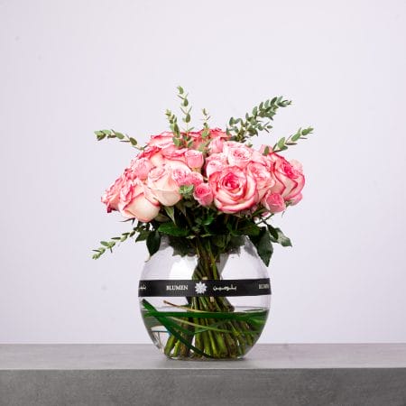 Elegant bouquet of red roses wrapped in deep red mesh with a blue BLUMEIN ribbon.