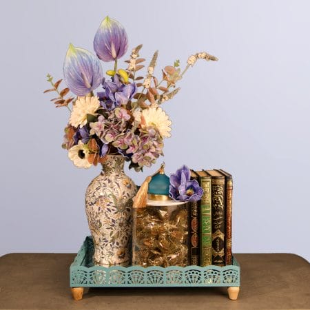 A luxurious vase containing flowers sided with dates.