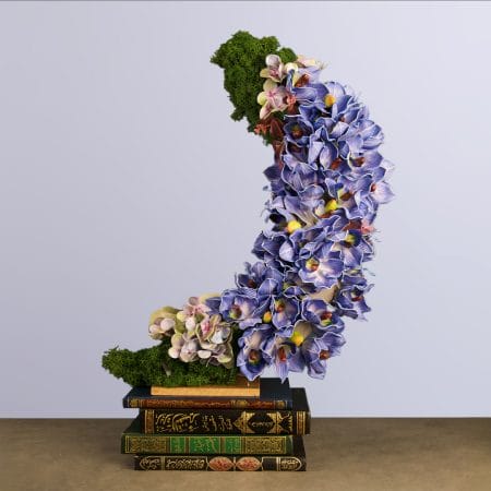 Crescent moon–shaped floral arrangement featuring purple orchids and lush green moss, styled with a Ramadan-inspired aesthetic.