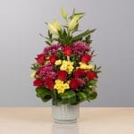 A luxurious floral arrangement featuring premium blooms, delicate seasonal flowers, and fresh greenery, elegantly arranged in a decorative vase.