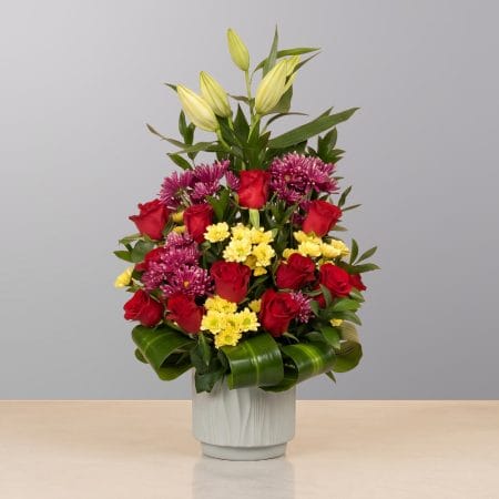 A luxurious floral arrangement featuring premium blooms, delicate seasonal flowers, and fresh greenery, elegantly arranged in a decorative vase.