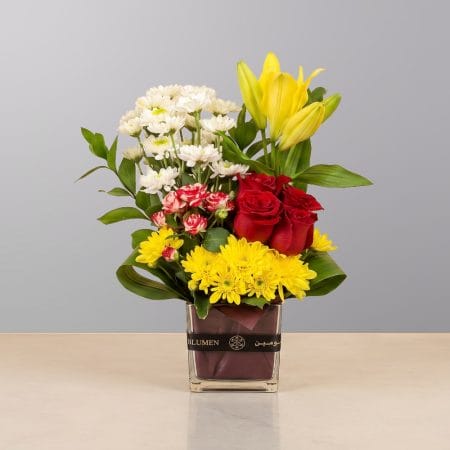 A cheerful floral arrangement featuring premium blooms, delicate seasonal flowers, and lush greenery, elegantly arranged in a decorative vase.