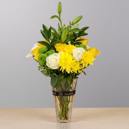 A vibrant floral arrangement featuring premium blooms, delicate seasonal flowers, and fresh greenery, elegantly arranged in a decorative vase.