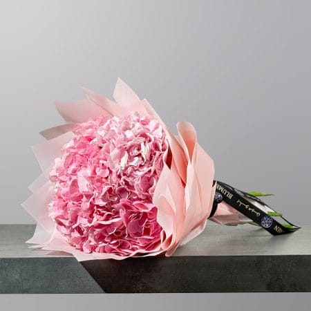 A luxurious bouquet of soft pink hydrangeas wrapped in elegant blush pink paper.