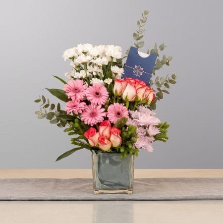 A graceful floral arrangement featuring premium blooms, delicate seasonal flowers, and fresh greenery, elegantly arranged in a decorative vase.