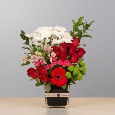 A luxurious floral arrangement featuring premium blooms, elegant seasonal flowers, and lush greenery, beautifully arranged in a decorative vase.
