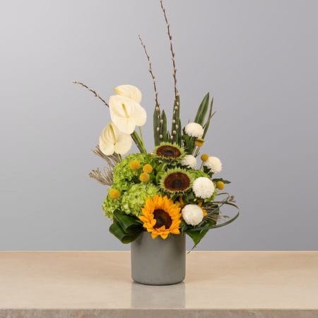 A luxurious floral arrangement featuring premium blooms, delicate seasonal flowers, and fresh greenery, elegantly arranged in a decorative vase.