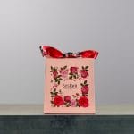 A small, pink bag of chocolates made by Bostani.