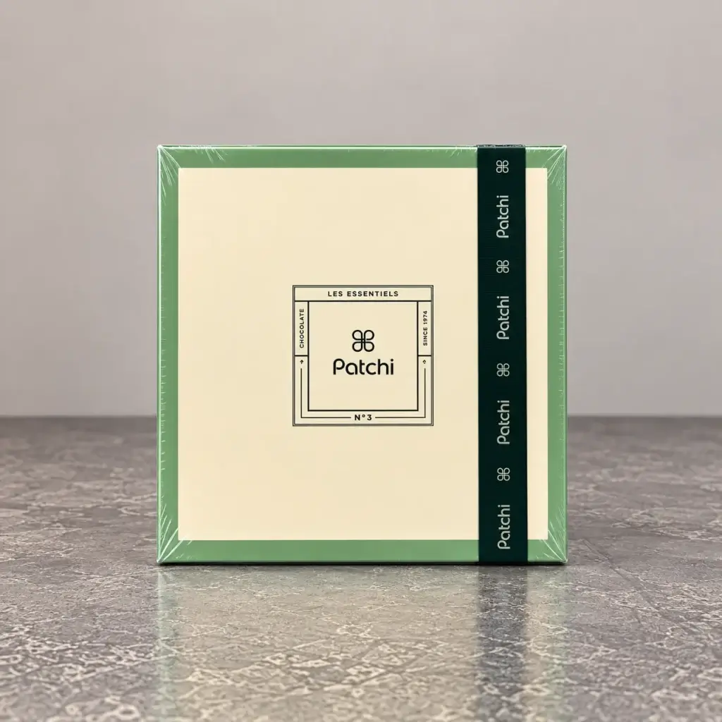 A white box with a dark green ribbon that has the Patchi logo on it.