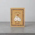 A beige card holder with the image of two white ducks embracing one another. 