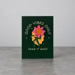 A green card holder with the image of a flower dancing.