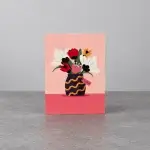 A pink card holder with the image of a vase.