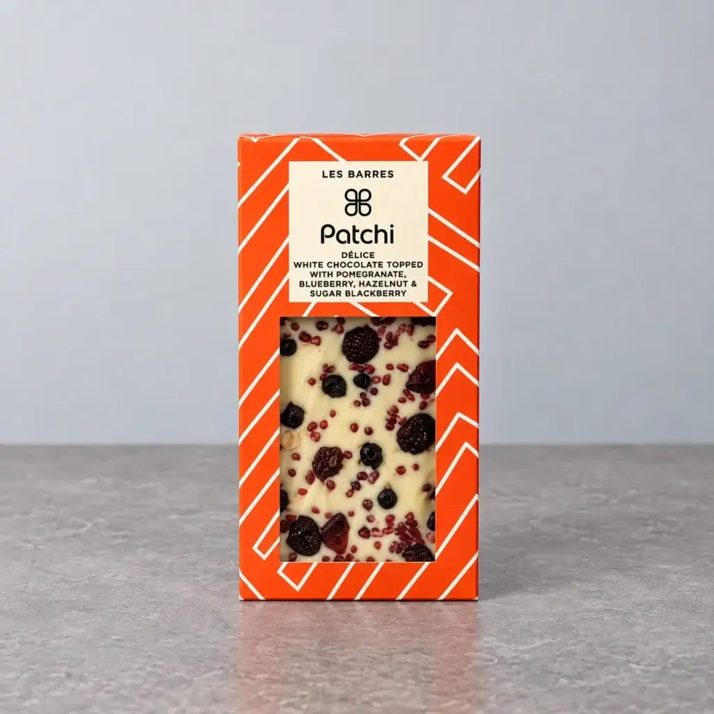 A white chocolate bar with hazelnuts and berries.